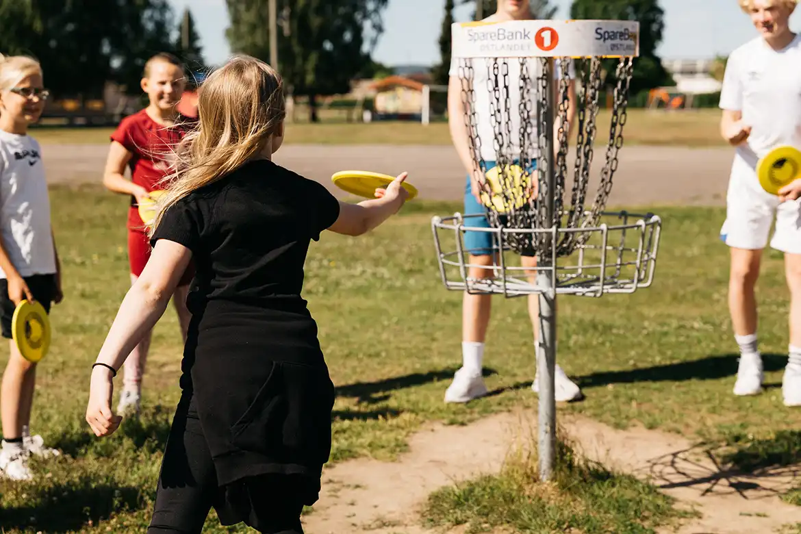 Skoleelever som spiller frisbeegolf