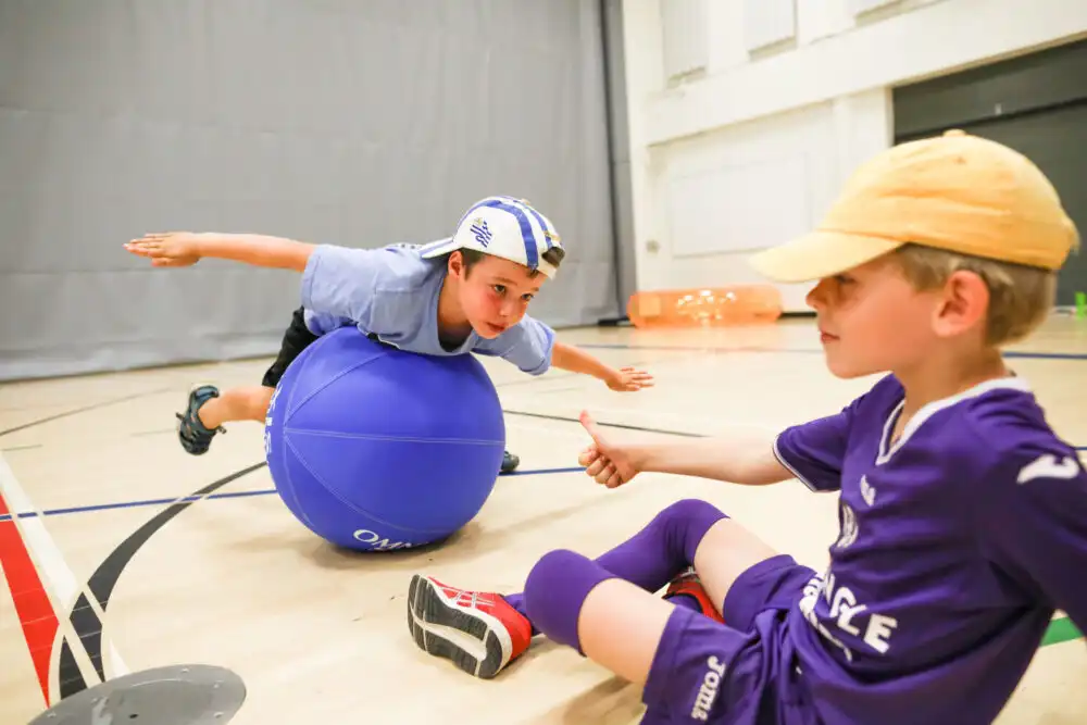 En gutt som utfører Omnikin Yoga øvelser på en Omnikin Six ball