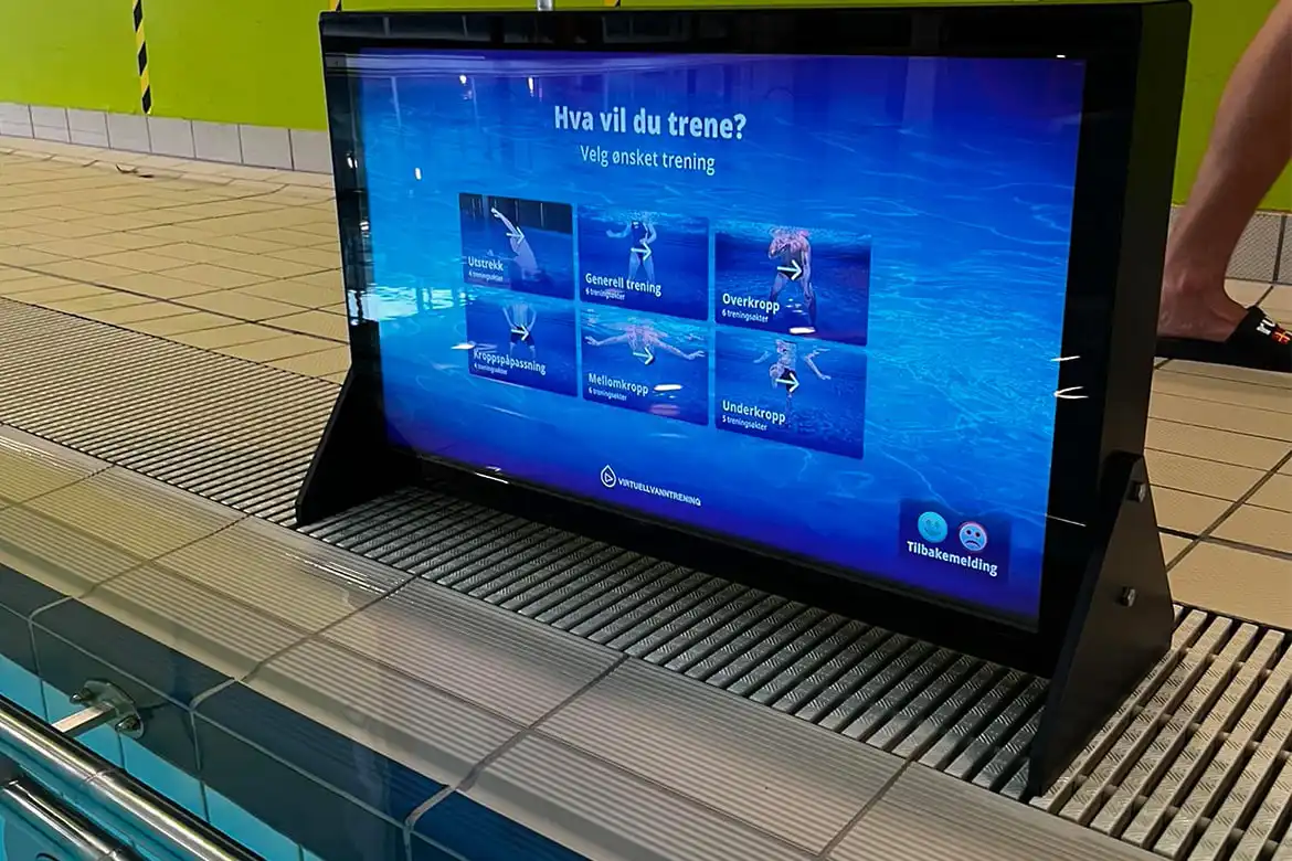 Skjerm for virituell vanntrening som står på bassengkanten