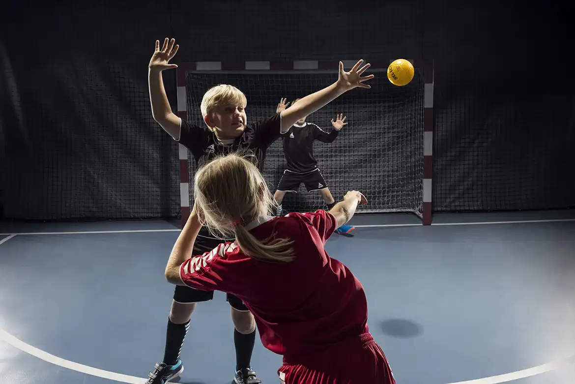 Barn som spiller håndball innendørs